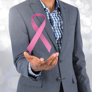 Male wearing a gray suit holding a pink ribbon.