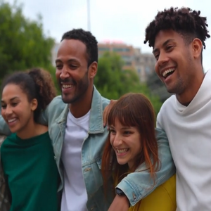 Group of friends walking outside with their arms around each other.